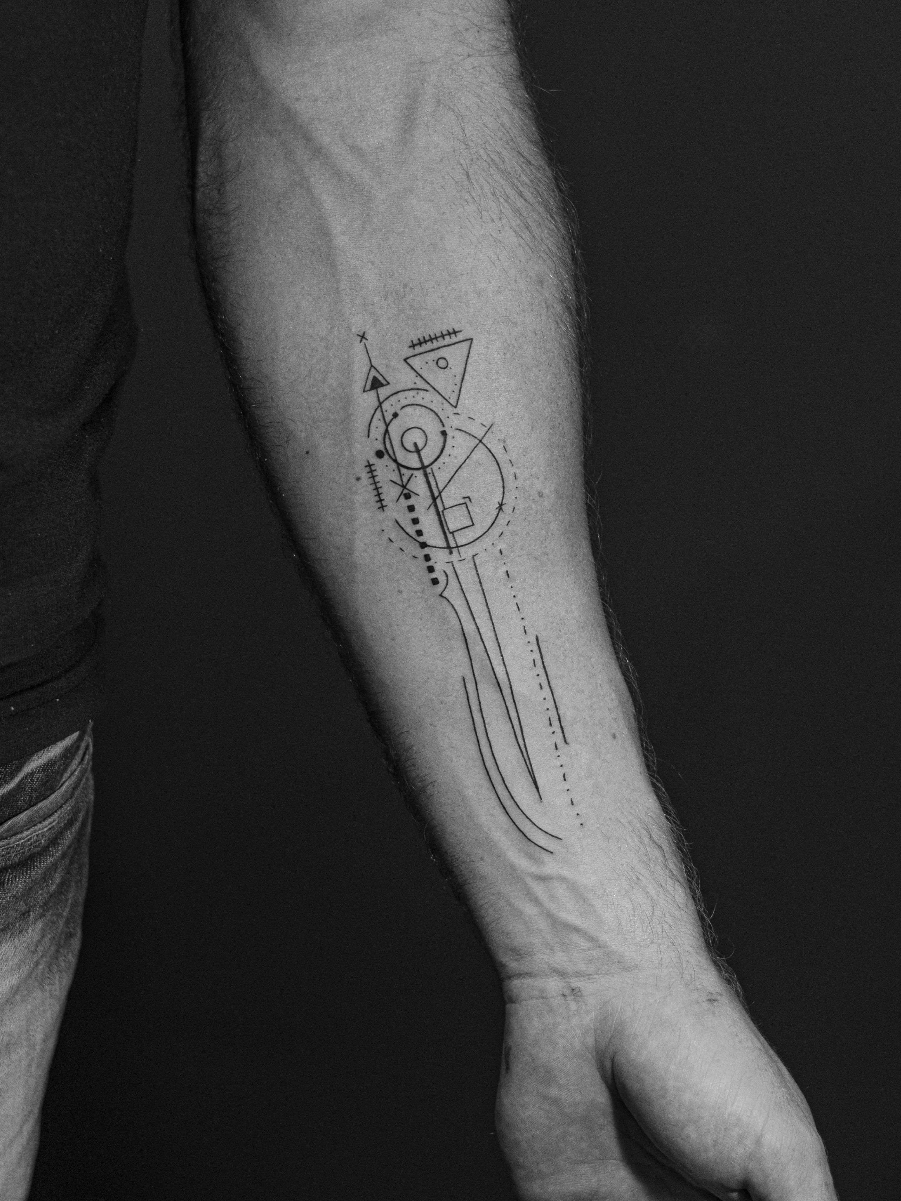 Minimalist tattoo made in fineline on the forearm area, representing abstract lines.