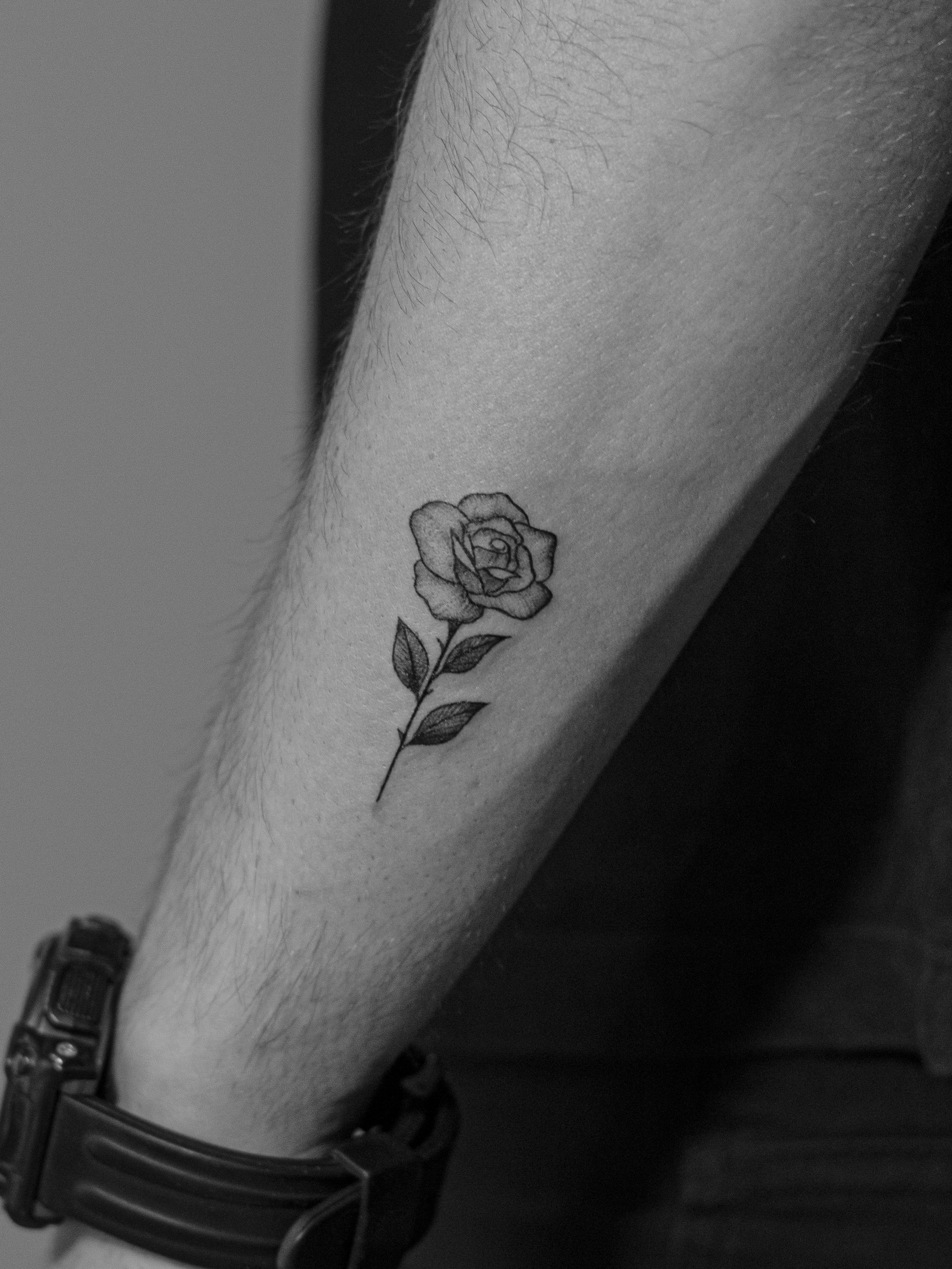 Minimalist tattoo made in fineline on the forearm area, representing a rose (flower).