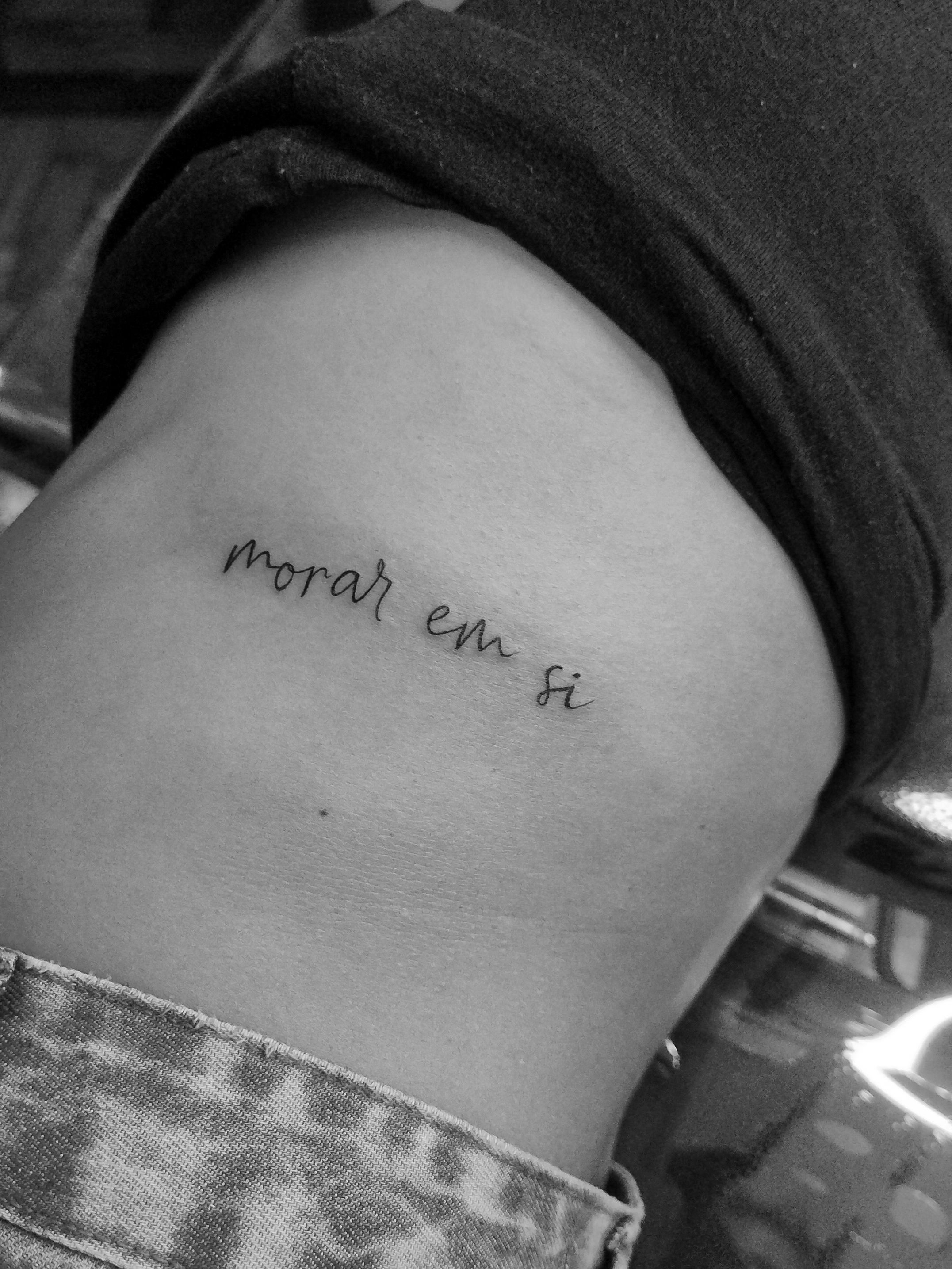 Minimalist tattoo made in fineline on the rib area, with the phrase "dwell within oneself".