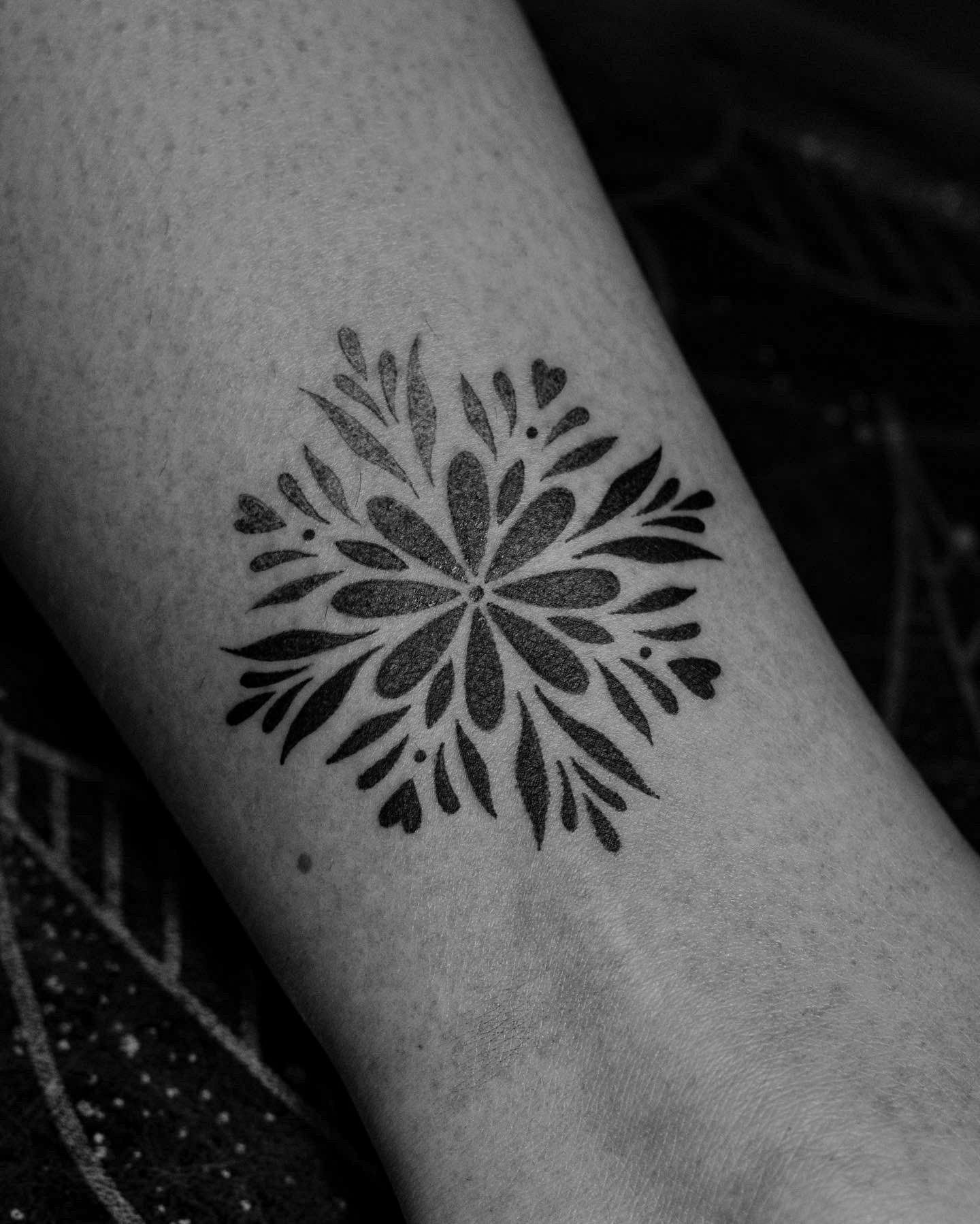 Tattoo made in dotwork on the calf area, representing a flower/mandala.