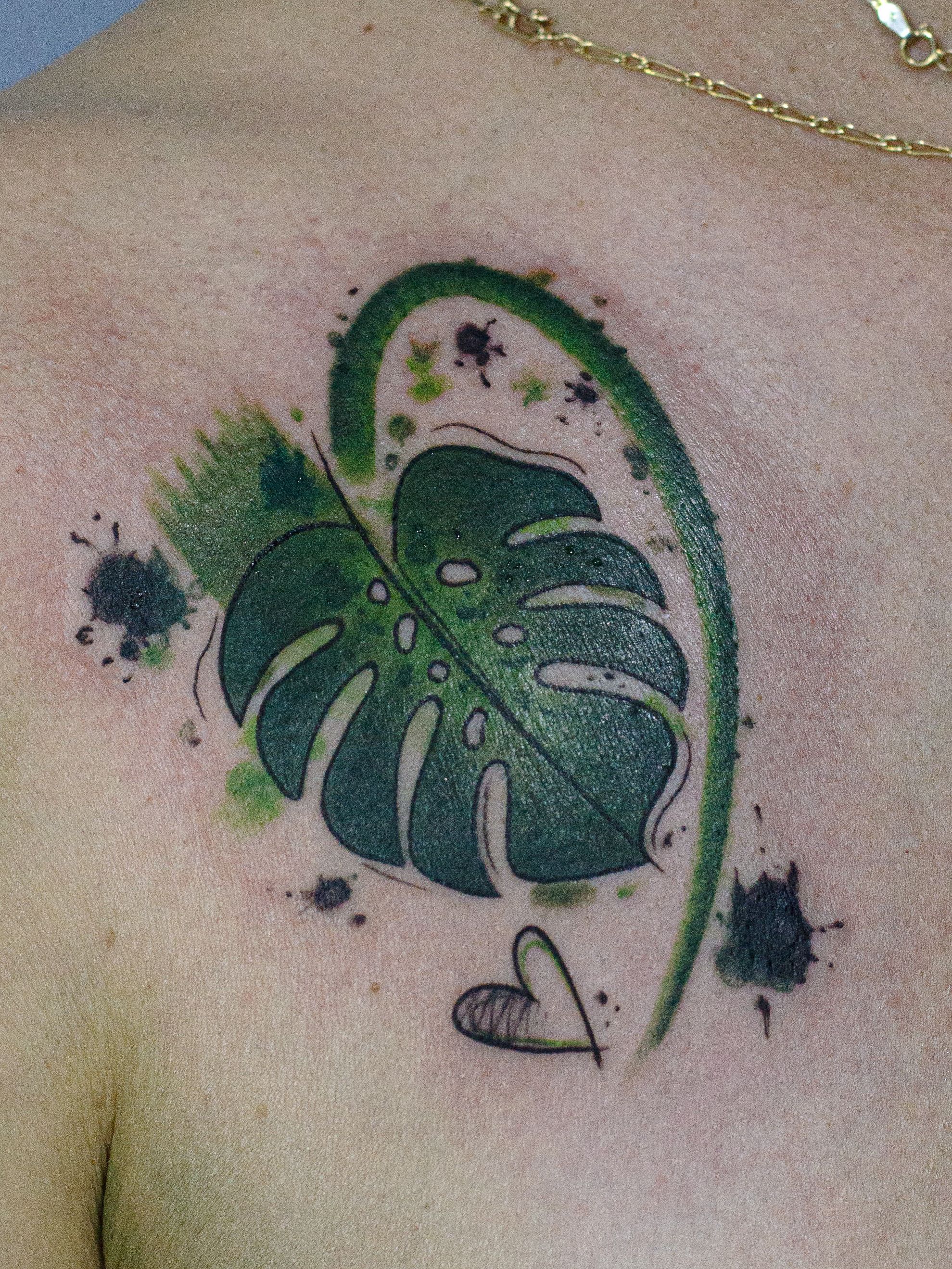 Tattoo made in fineline, colored watercolor style, sketch style, representing a leaf of the "monstera deliciosa" plant.
