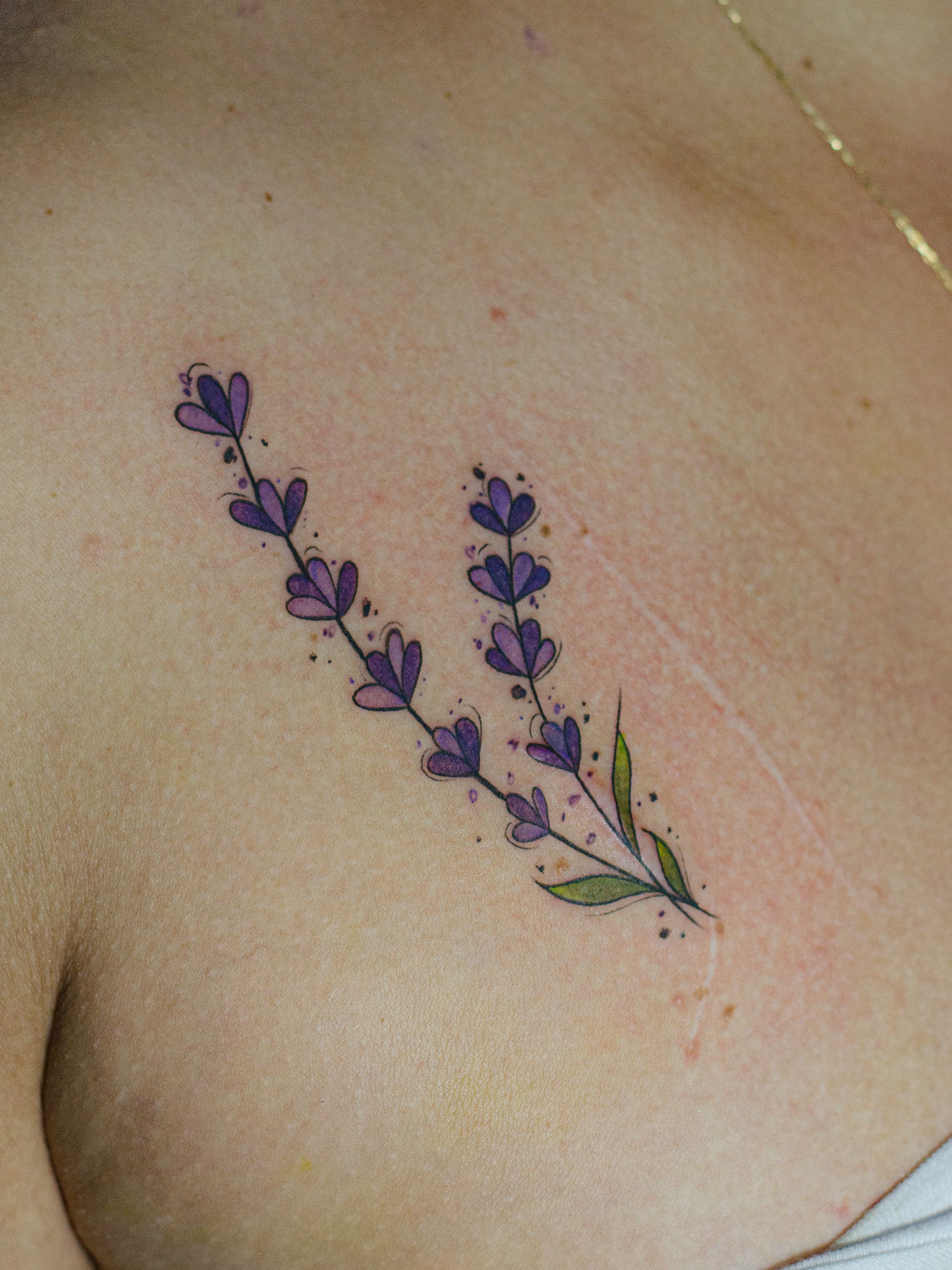 Minimalist tattoo made in fineline, colored watercolor style, sketch style, representing a small lavender branch.