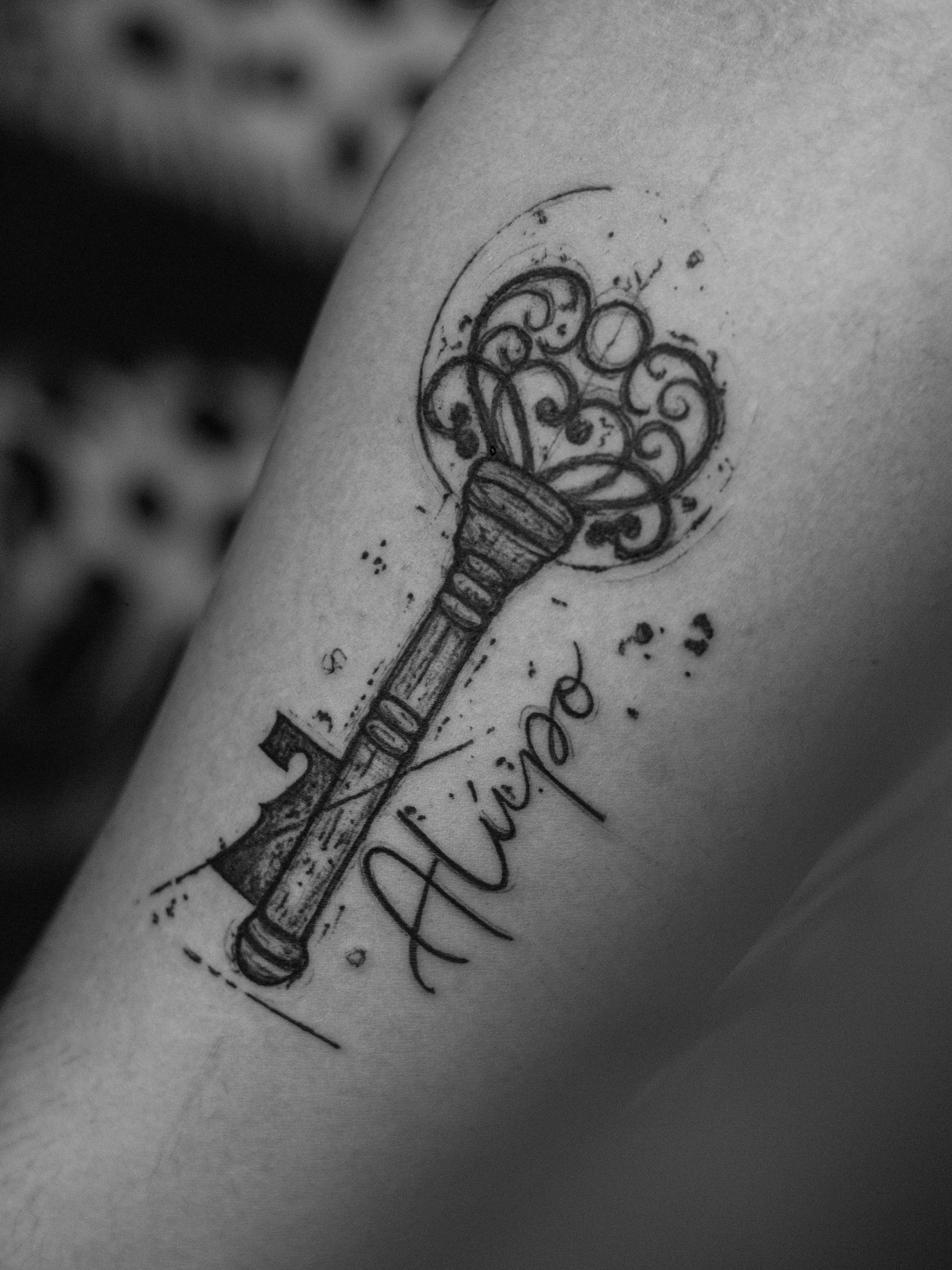 Minimalist tattoo, only in black (blackwork), sketch style, on the forearm area, representing a key and the number 7, which symbolizes "Exu Bará".