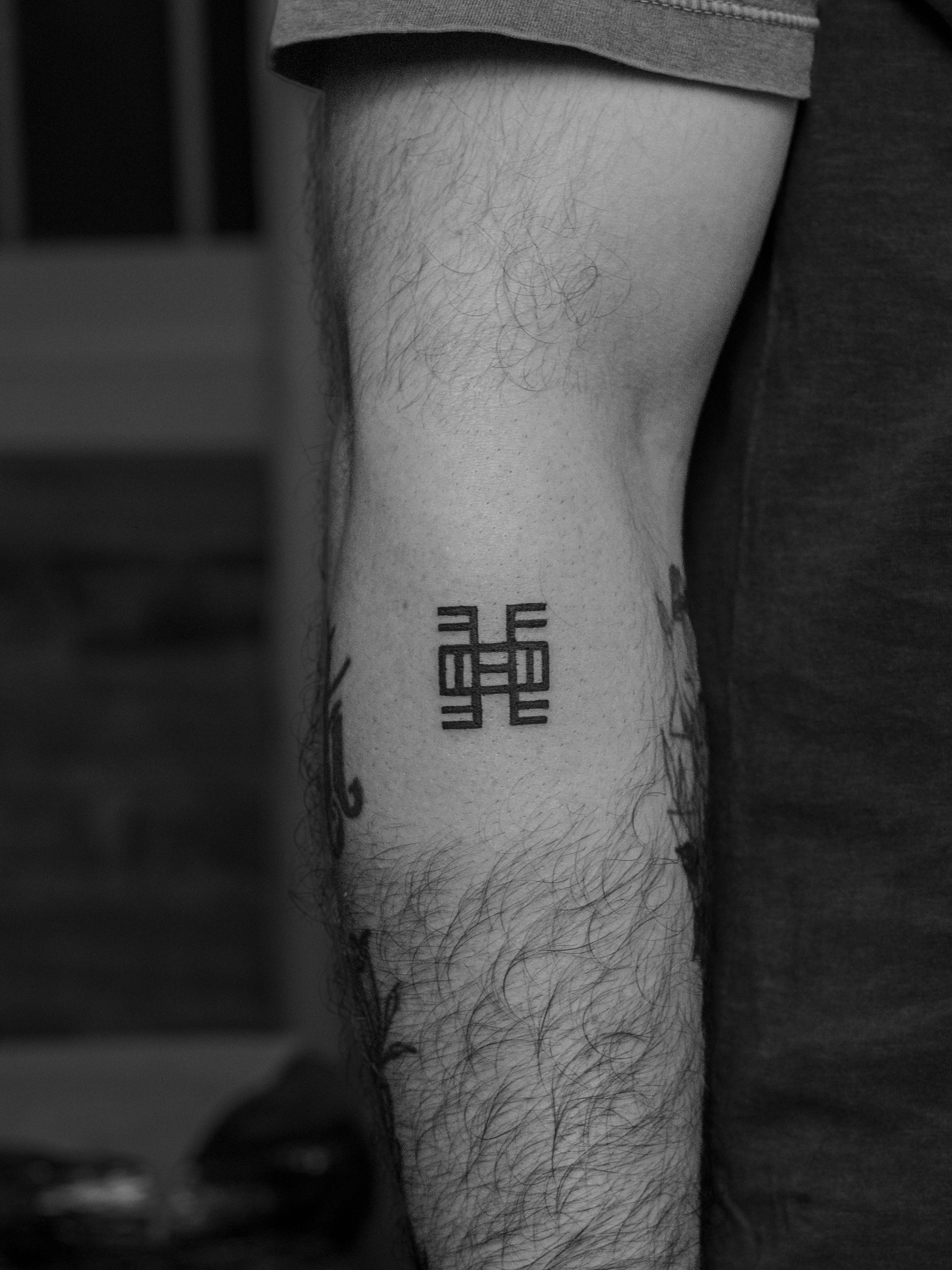 Minimalist tattoo, only in black (blackwork), on the forearm area, representing the Adinkra symbol "Nea onnim no sua a, ohu” which means “he who does not know, can learn”.